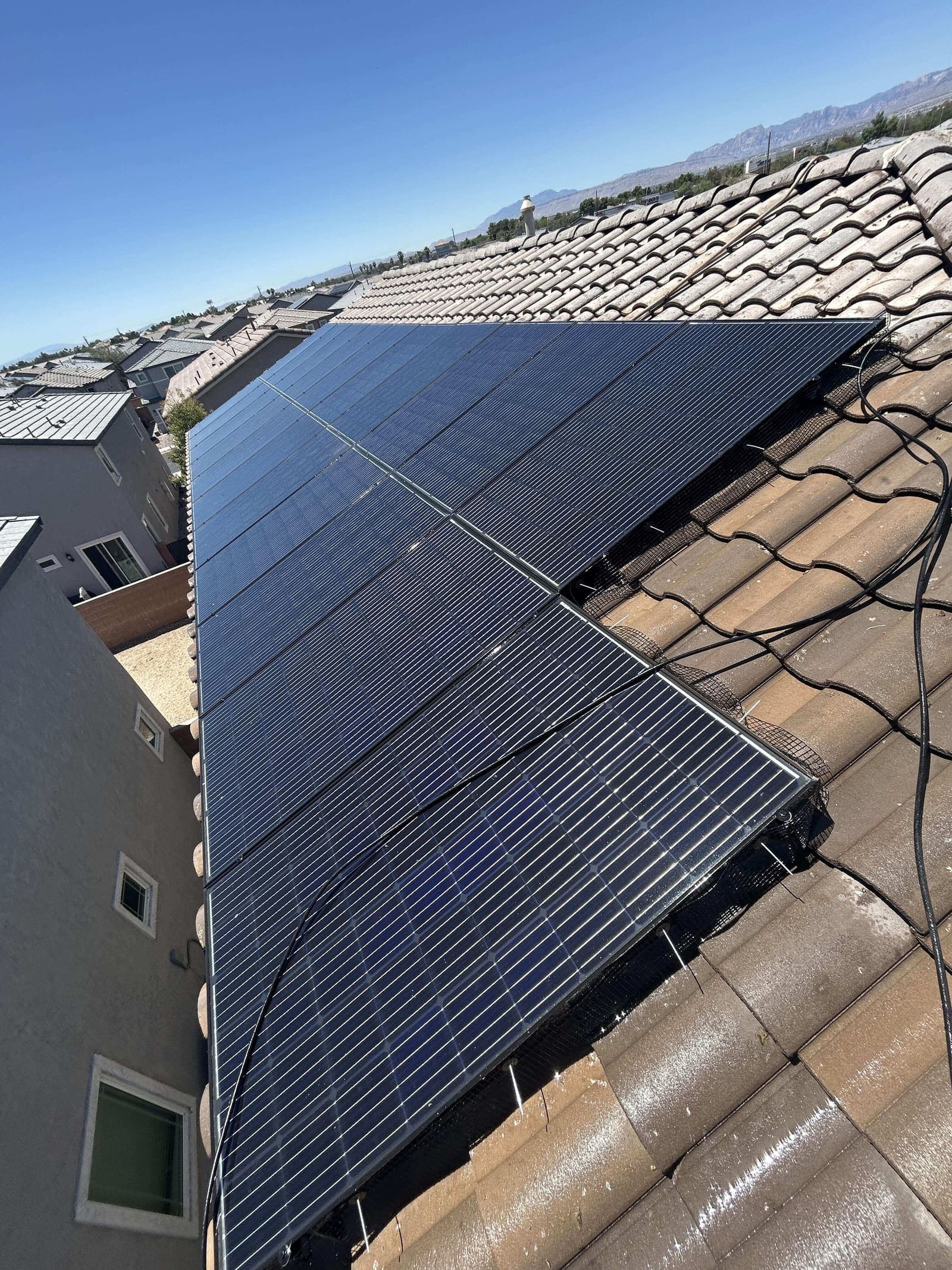 Wide view of clean solar panels under a blue desert sky